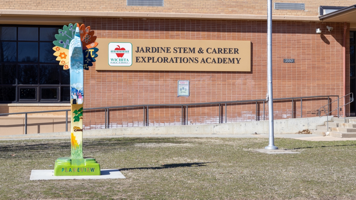 A colorful sculpture in front of a brick building