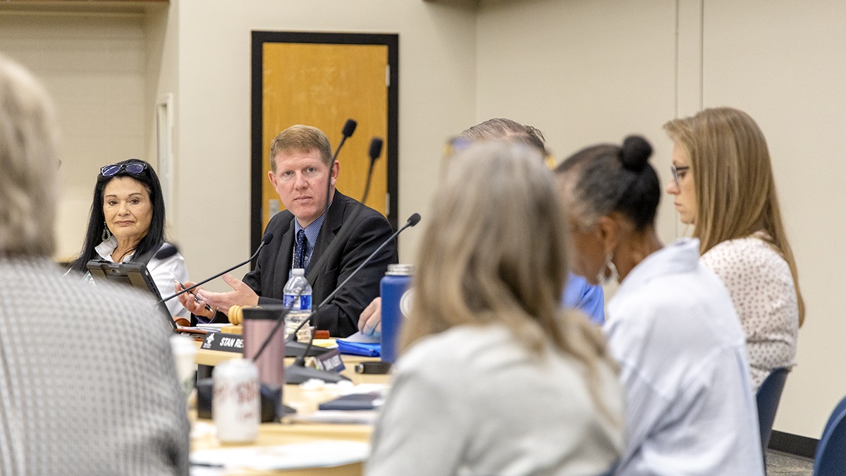 People talk at a government meeting.