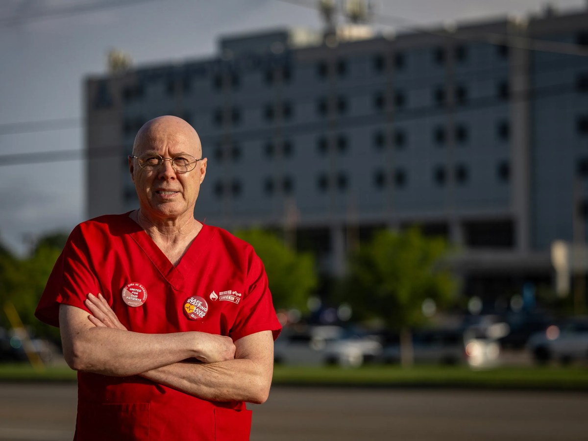 Marvin Ruckle stands with his arms crossed in a red shirt.