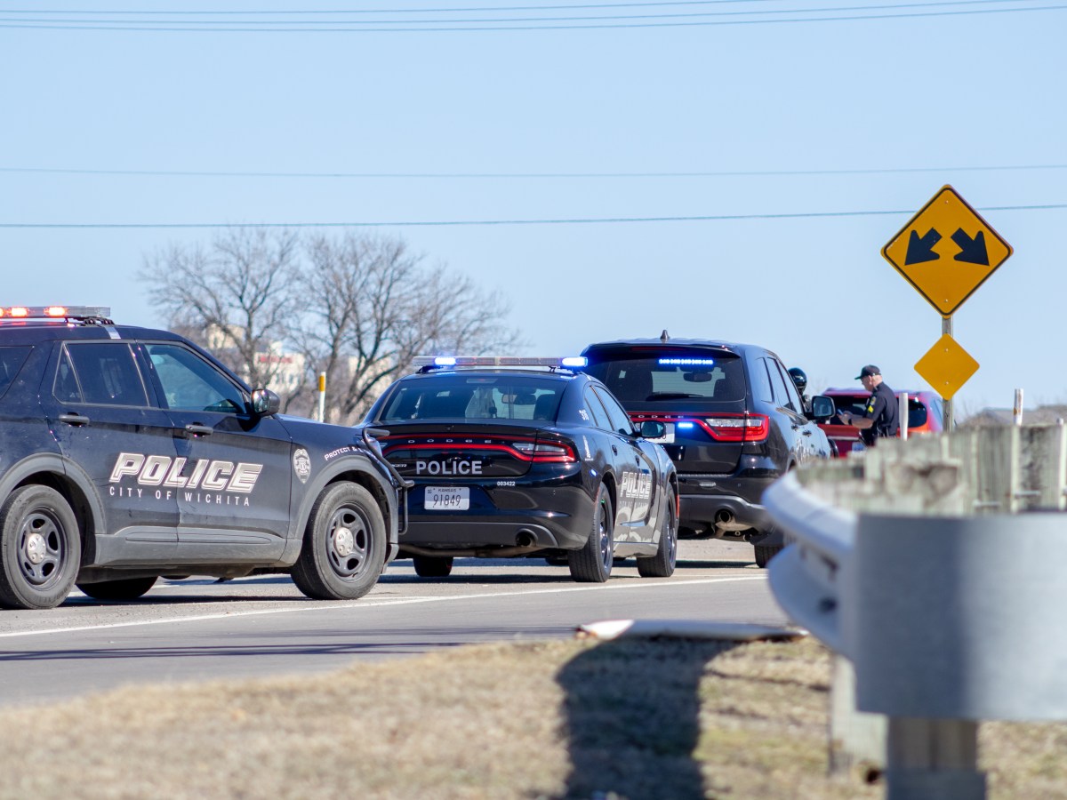 Three Wichita police cars have their lights on during a stop.