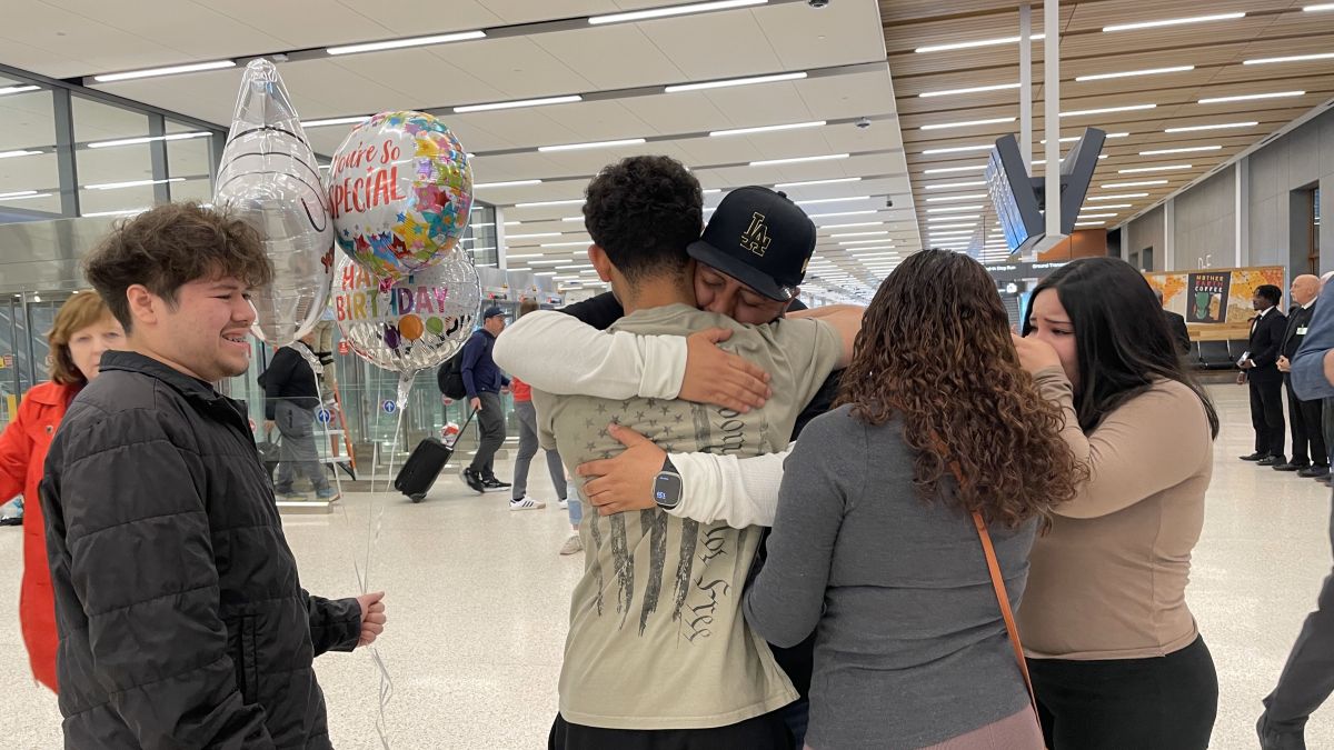 Evenezer Cortez Martinez, a DACA recipient who was deported last week, embraces members of his family at Kansas City International Airport.