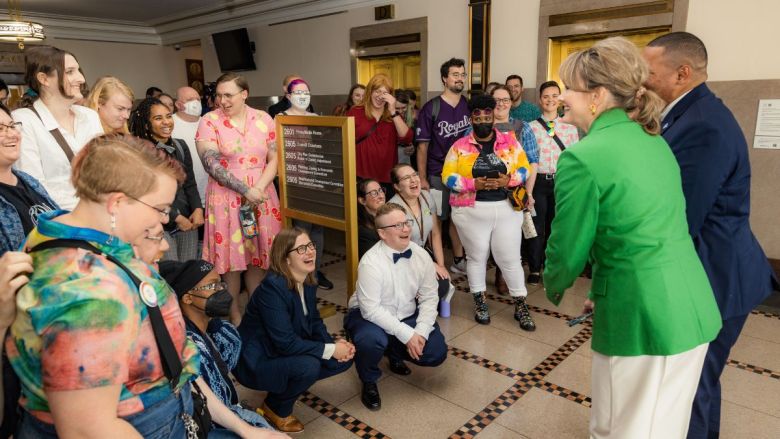 A couple dozen people gathered in Kansas City Hall, smiling and celebrating with city officials.