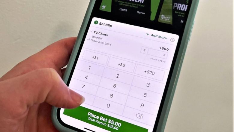 Someone holding a phone. They are about to place a bet on a sportbook.