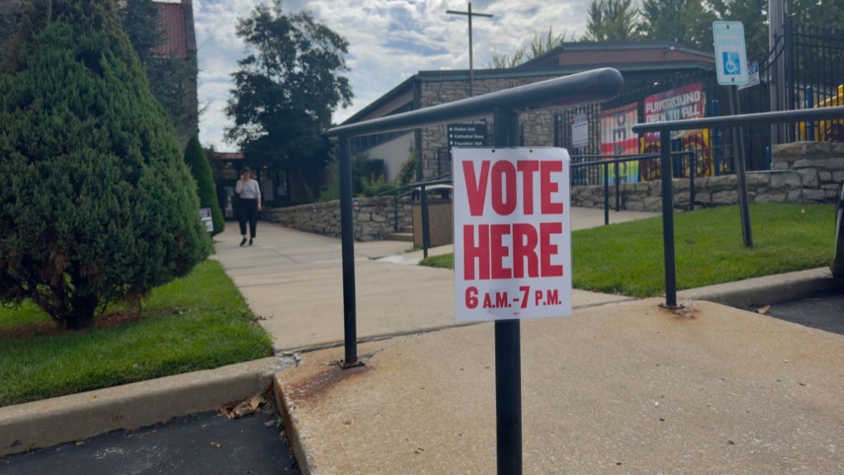 A sign in front of a church that says, "Vote here."