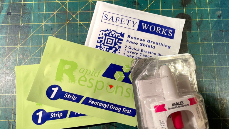 Narcan and fentanyl test strips sit on a table in their packaging.