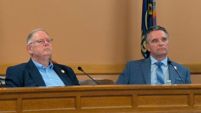 Dan Hawkins and Ty Masterson sit at a committee meeting.