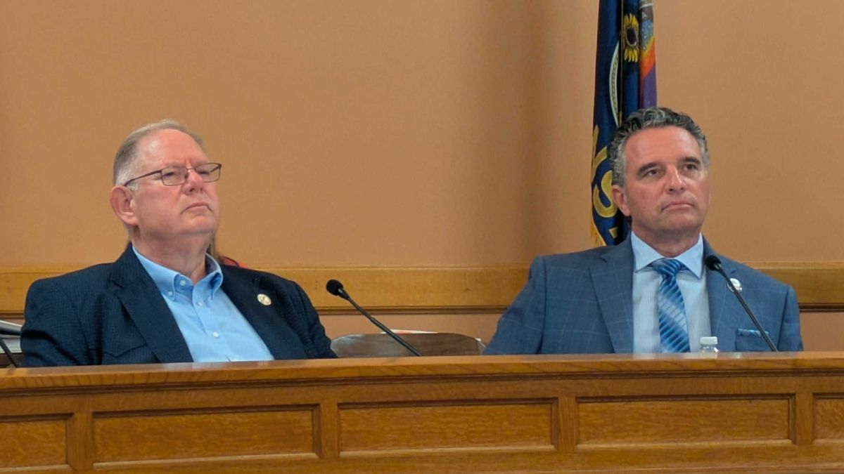 Dan Hawkins and Ty Masterson sit at a committee meeting.