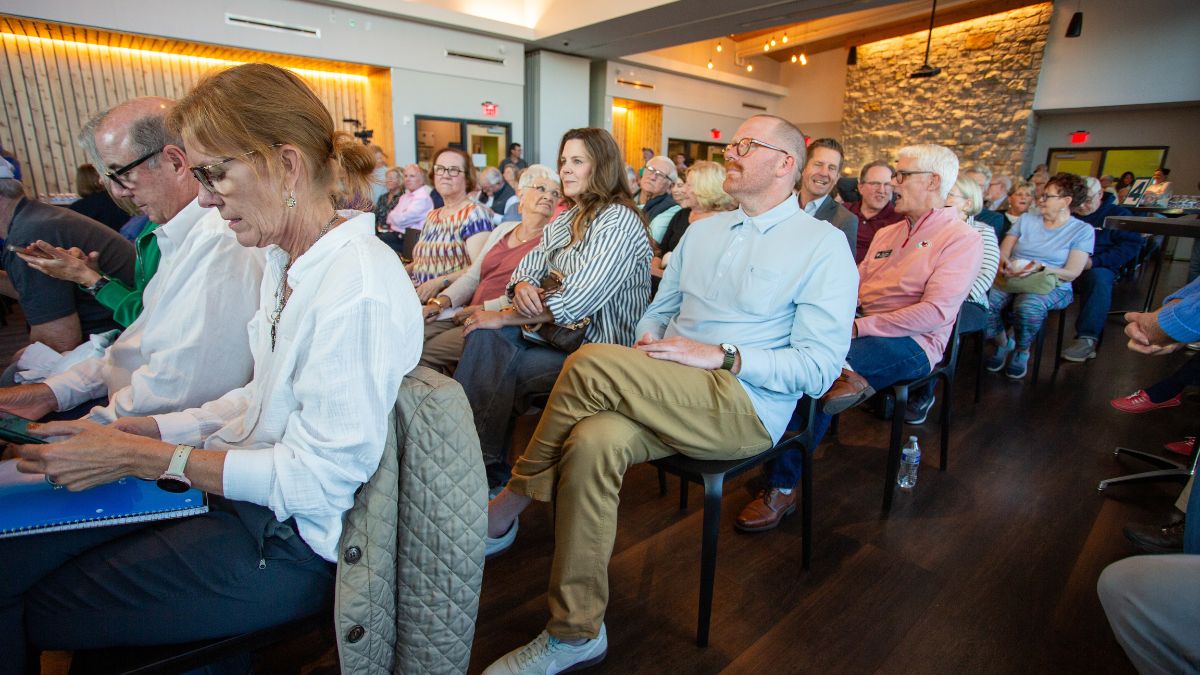 Dozens of Prairie Village residents seated in chairs at the Meadowbrook Park Clubhouse, talking amongst themselves while they wait for the candidate forum to start.