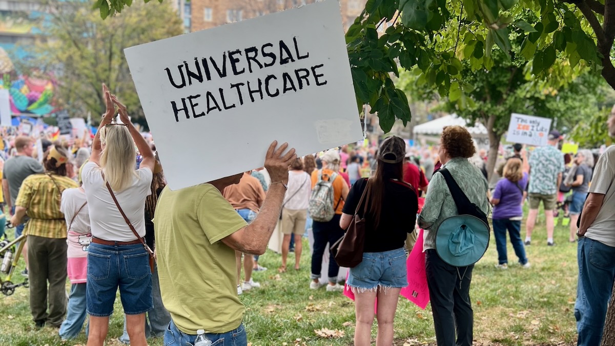 A protester carying a 'Universal Healthcare' sign at an Oct. 18 rally in Kansas City.