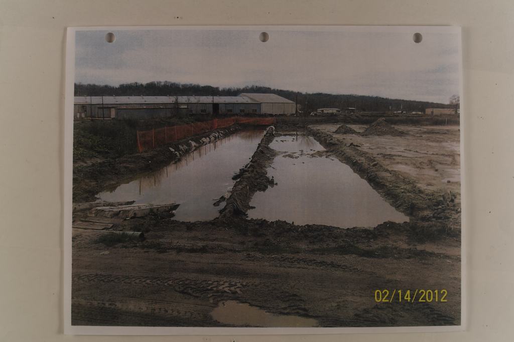 A photo provided by Raymond Williams shows flooded trenches where U.S. Technology employees were in the process of digging up buried sandblasting powder during the cleanup of the Hydromex site in Yazoo City, Mississippi, in 2012.