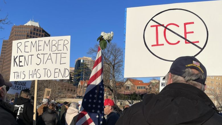 Protesters carrying signs and the American flag at Mill Creek Park near the Country Club Plaza