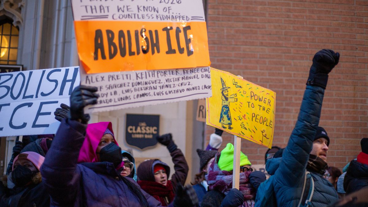 Protestors holding signs that read, "Abolish ICE" and "Power to the people."