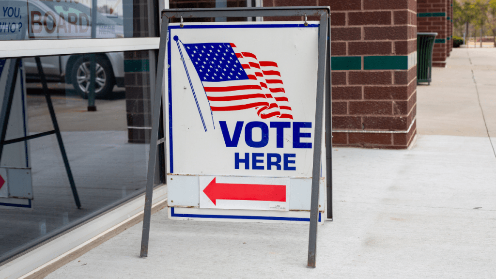 Vote here sign in front of a glass window