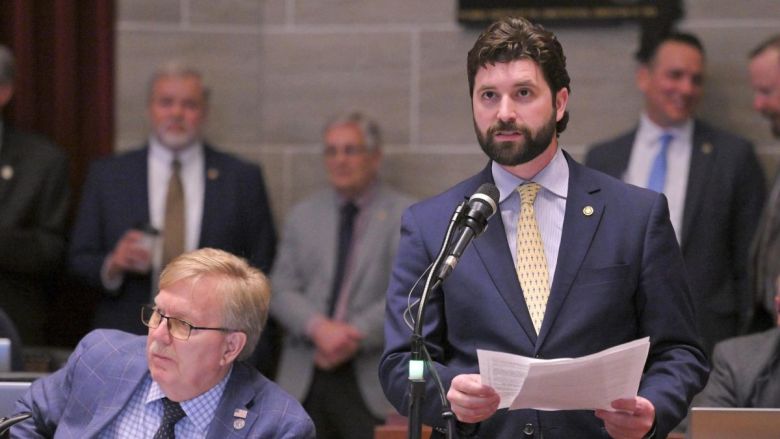 A bearded man in a gray suit speaks during a debate at the Missouri Statehouse.