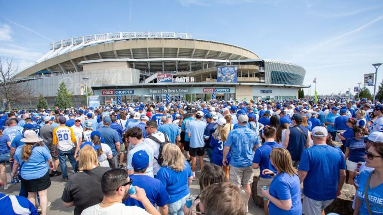 Fans dressed in blue gather outside the entrance to Kauffman Stadium on game day