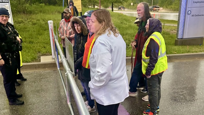 Ann Suellentrop, vice chair of PeaceWorks Kansas City, with other protesters outside the Kansas City National Security Campus on Botts Road.