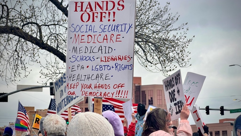 Protesters on the Plaza in April of 2025 holding a sign supporting Medicaid.