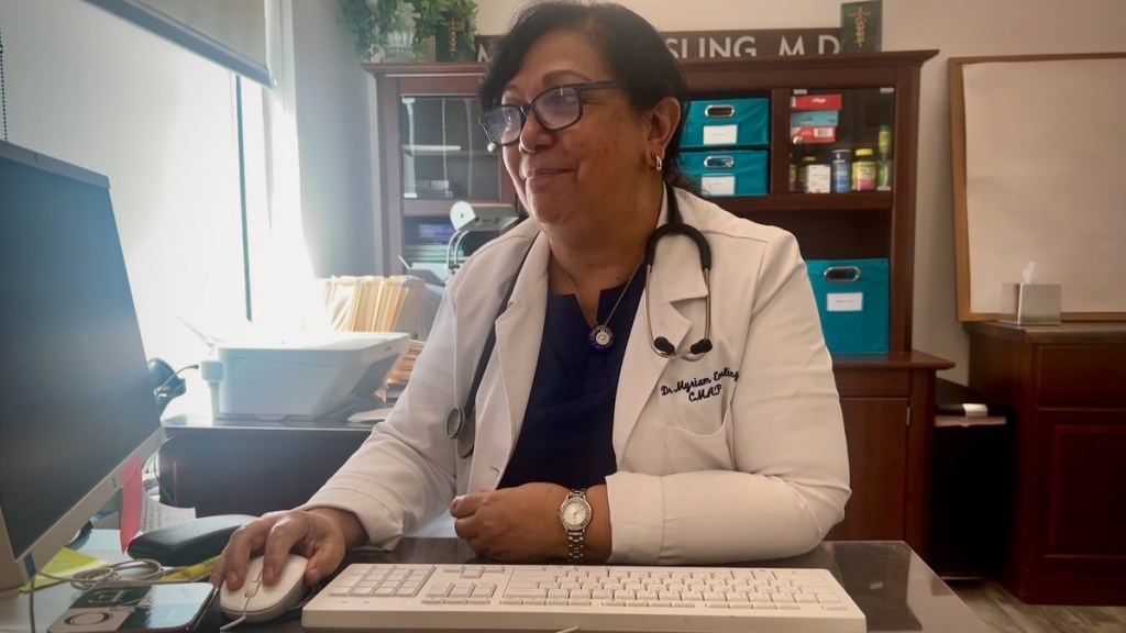 Dr. Myriam Ensling sitting behind a desk in her Brookside health clinic.