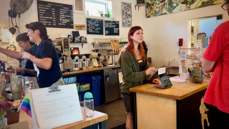Lilli Juarez, a barista at Oddly Correct, a coffee shop on Troost Avenue, takes an order from a customer.