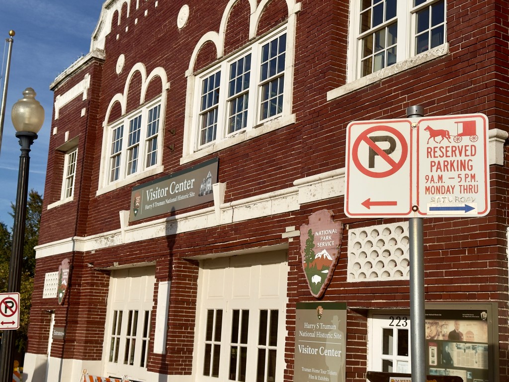 The Old Fire Station 1. In front of the building is a road sign with a horse-drawn carriage labeled "No parking."