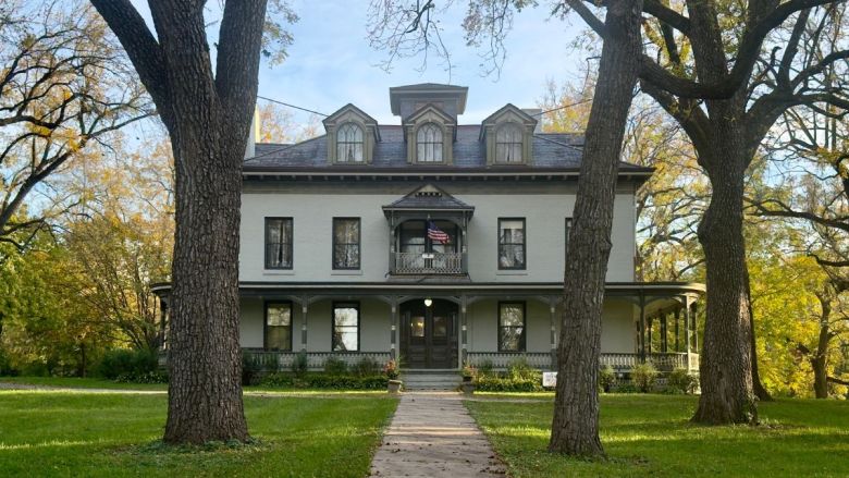 The main house of the Bingham-Waggoner estate seen through trees down a pathway.