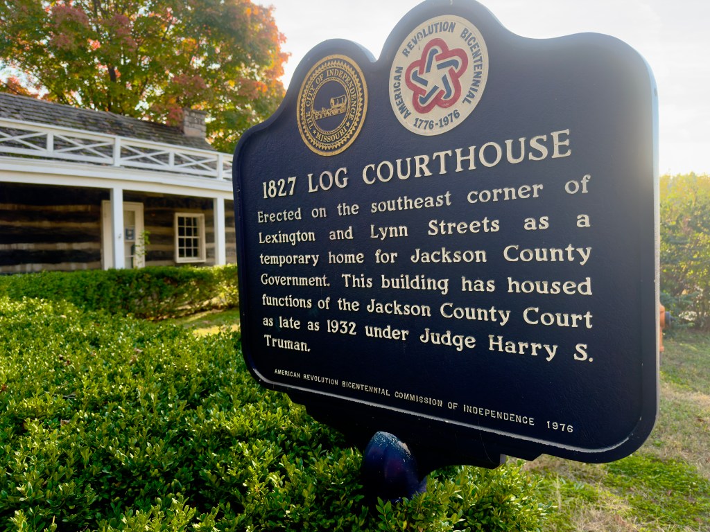 A historic marker for the 1827 Log Courthouse